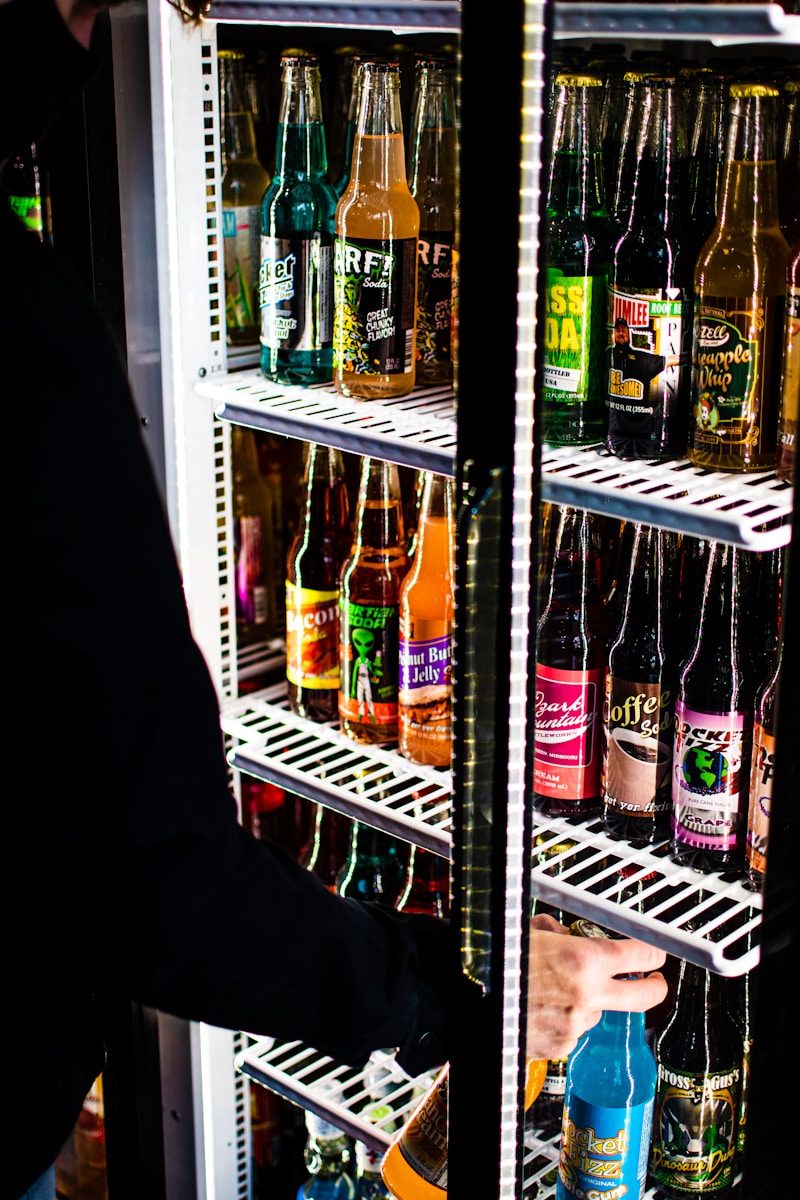 Række af displaykøleskabe med glaslåger i butik fyldt med drikkevarer